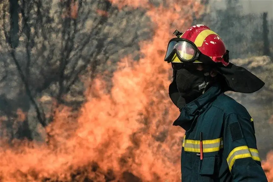 Πυροσβέστης με φθαρμένο κράνος Δασοπυροσβέστης με φθαρμένο κράνος και ανακλαστικές λωρίδες